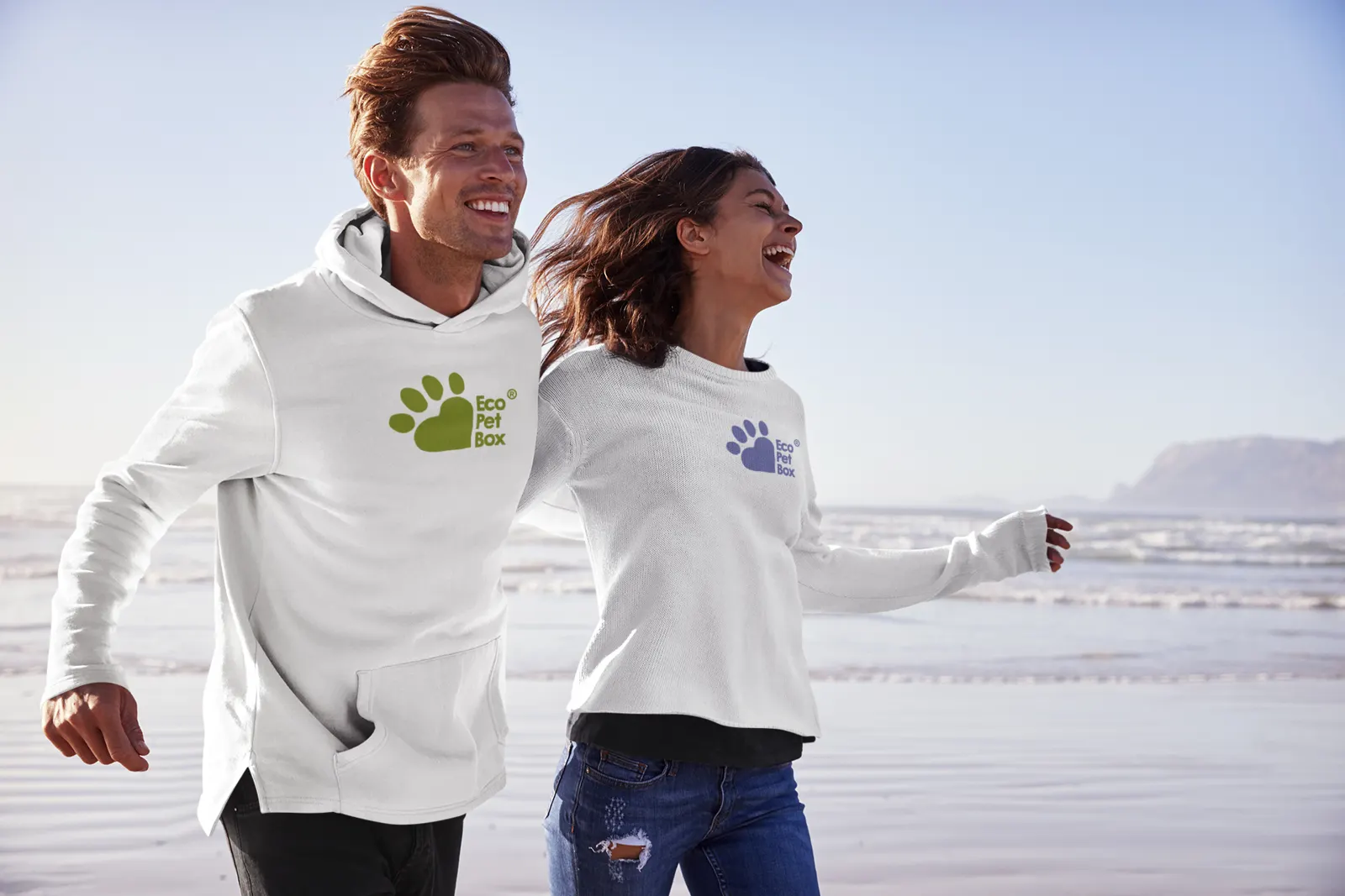 Ein Paar läuft am Strand in EcoPetBox-Sweatshirts – sorgloser, aktiver Lebensstil